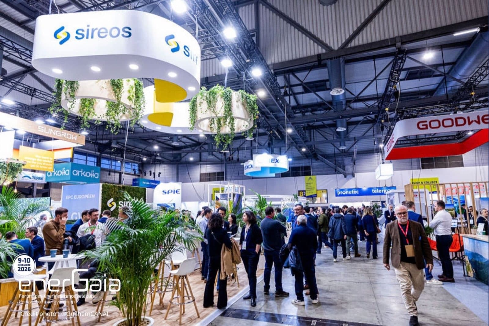 Pasillo central del Foro EnerGaïa, con stands decorados con plantas